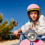 portrait-young-woman-wearing-helmet-sitting-scooter-against-road-freedom-summer-adventures-vacation.webp